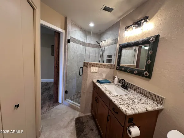 a bathroom with a granite countertop sink and a mirror