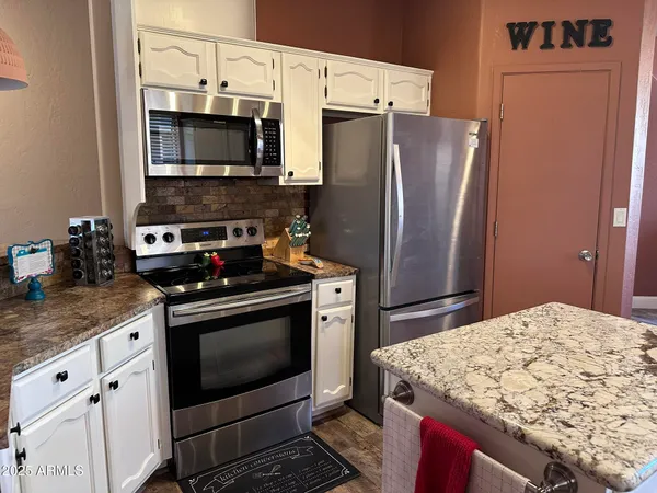 a kitchen with stainless steel appliances granite countertop a stove refrigerator and microwave