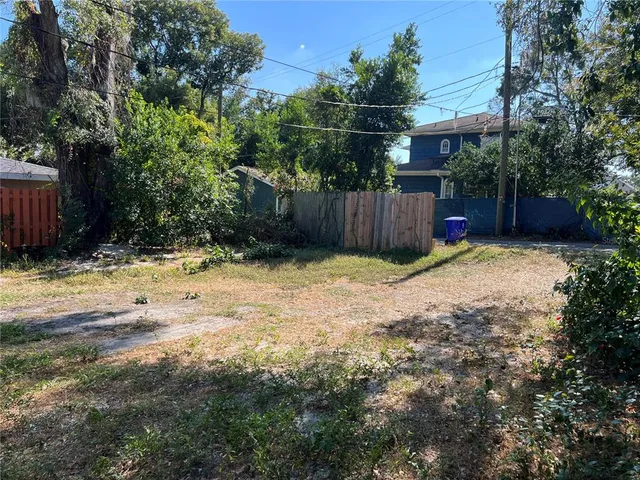 a view of backyard and wooden fence