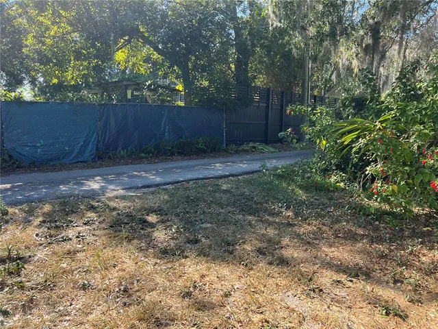 a view of a yard with wooden fence