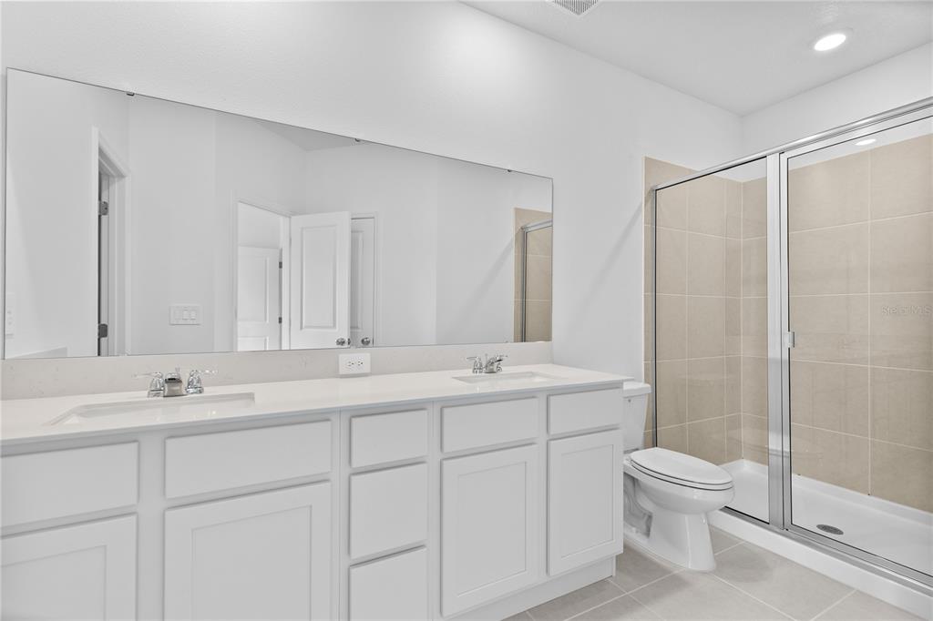624 Poppy Lane Dundee, FL 33838 - Photo 11 of 23 a bathroom with a double vanity sink toilet and shower