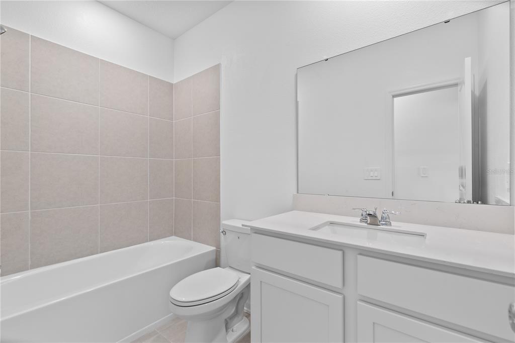 624 Poppy Lane Dundee, FL 33838 - Photo 14 of 23 a bathroom with a sink a toilet and a bathtub