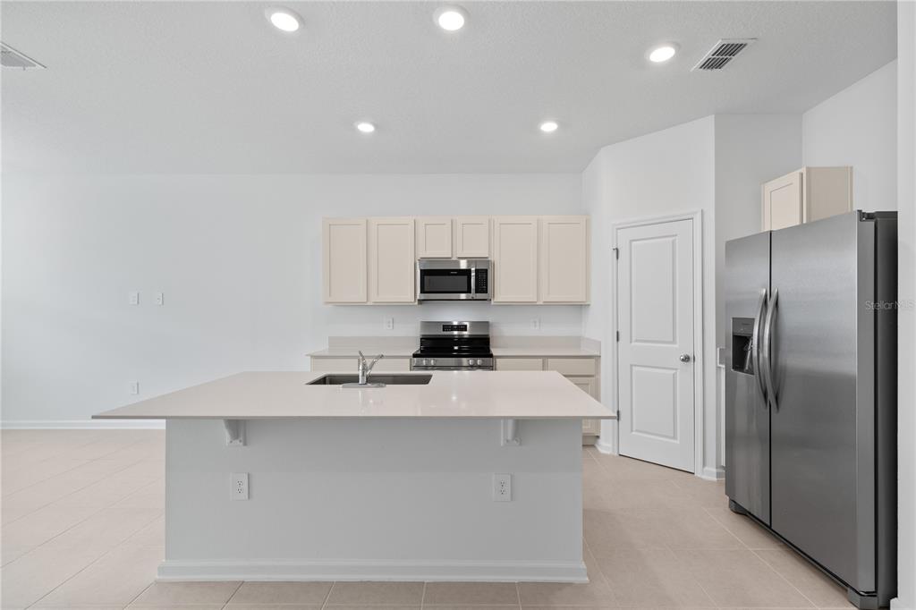 624 Poppy Lane Dundee, FL 33838 - Photo 4 of 23 a kitchen with stainless steel appliances a refrigerator sink and stove