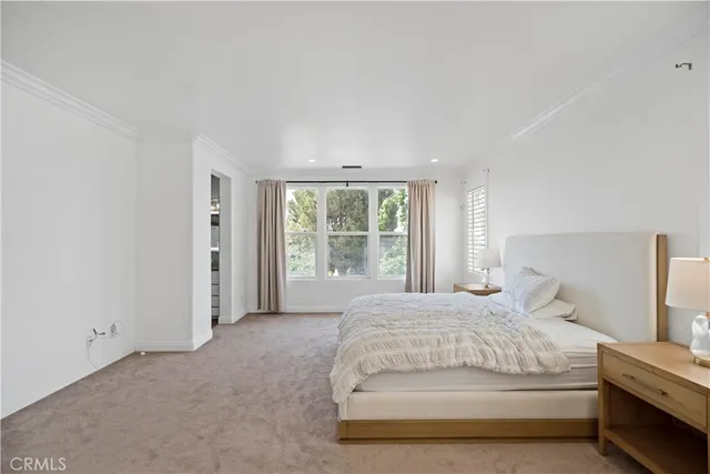 a large bed sitting in a bedroom next to a window