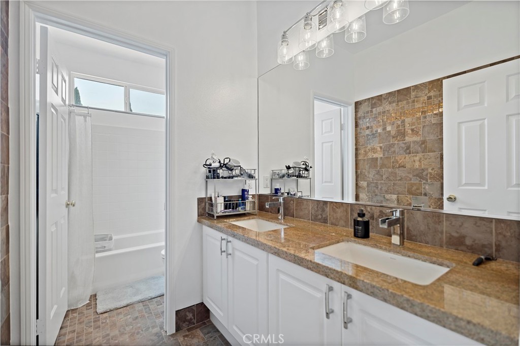 11855 Modena Drive Rancho Cucamonga, CA 91701 - Photo 26 of 30 a bathroom with a granite countertop sink a mirror and a shower