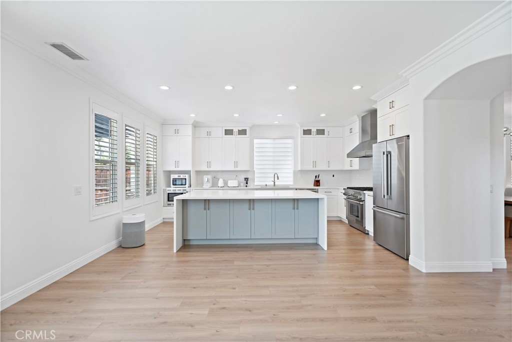 11855 Modena Drive Rancho Cucamonga, CA 91701 - Photo 9 of 30 a large white kitchen with stainless steel appliances granite countertop a stove a sink dishwasher and a refrigerator with wooden floor