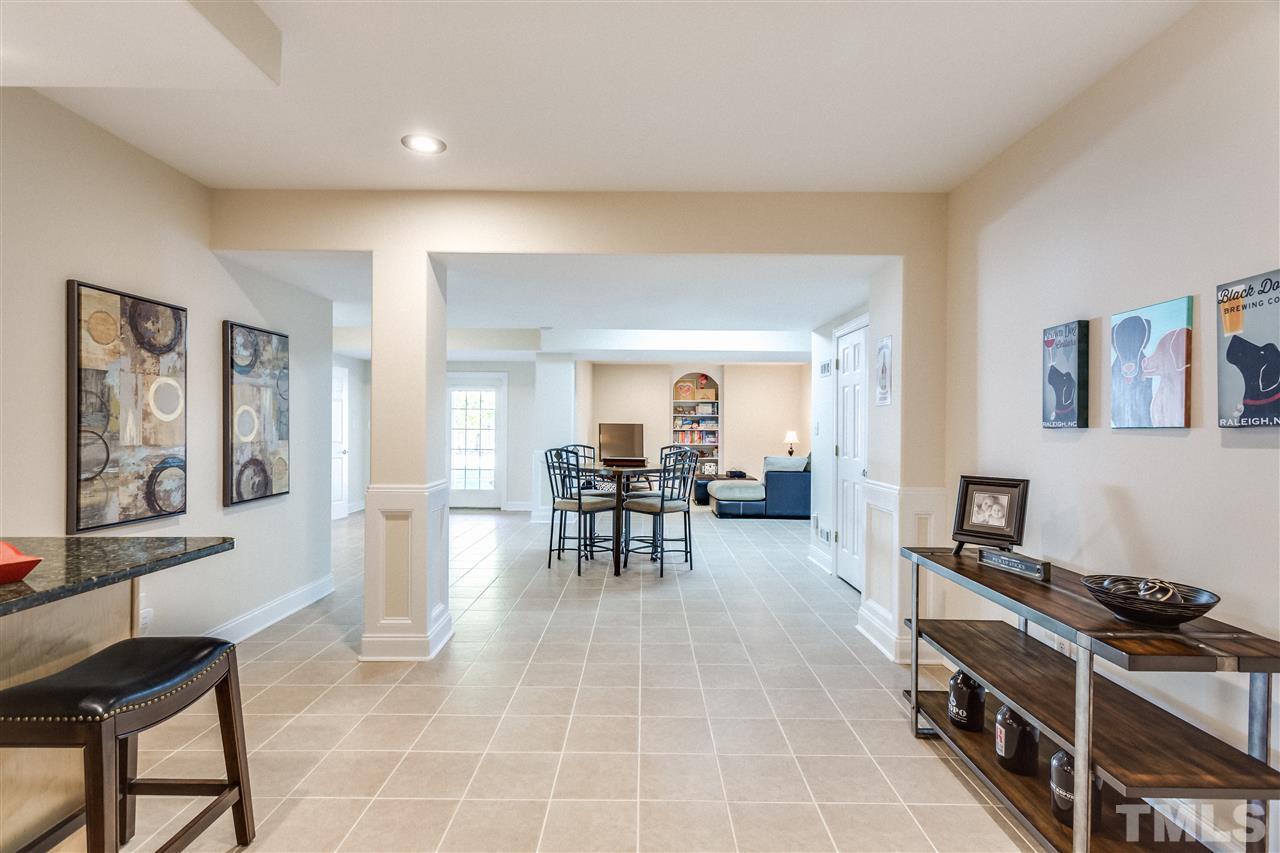 9004 Shellwood Court Raleigh, NC 27617 - Photo 17 of 25 a living room with furniture a dining table and a stove top oven