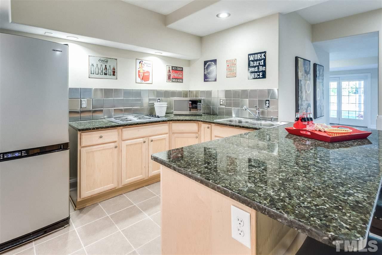 9004 Shellwood Court Raleigh, NC 27617 - Photo 18 of 25 a room with kitchen island a sink a stove and white cabinets