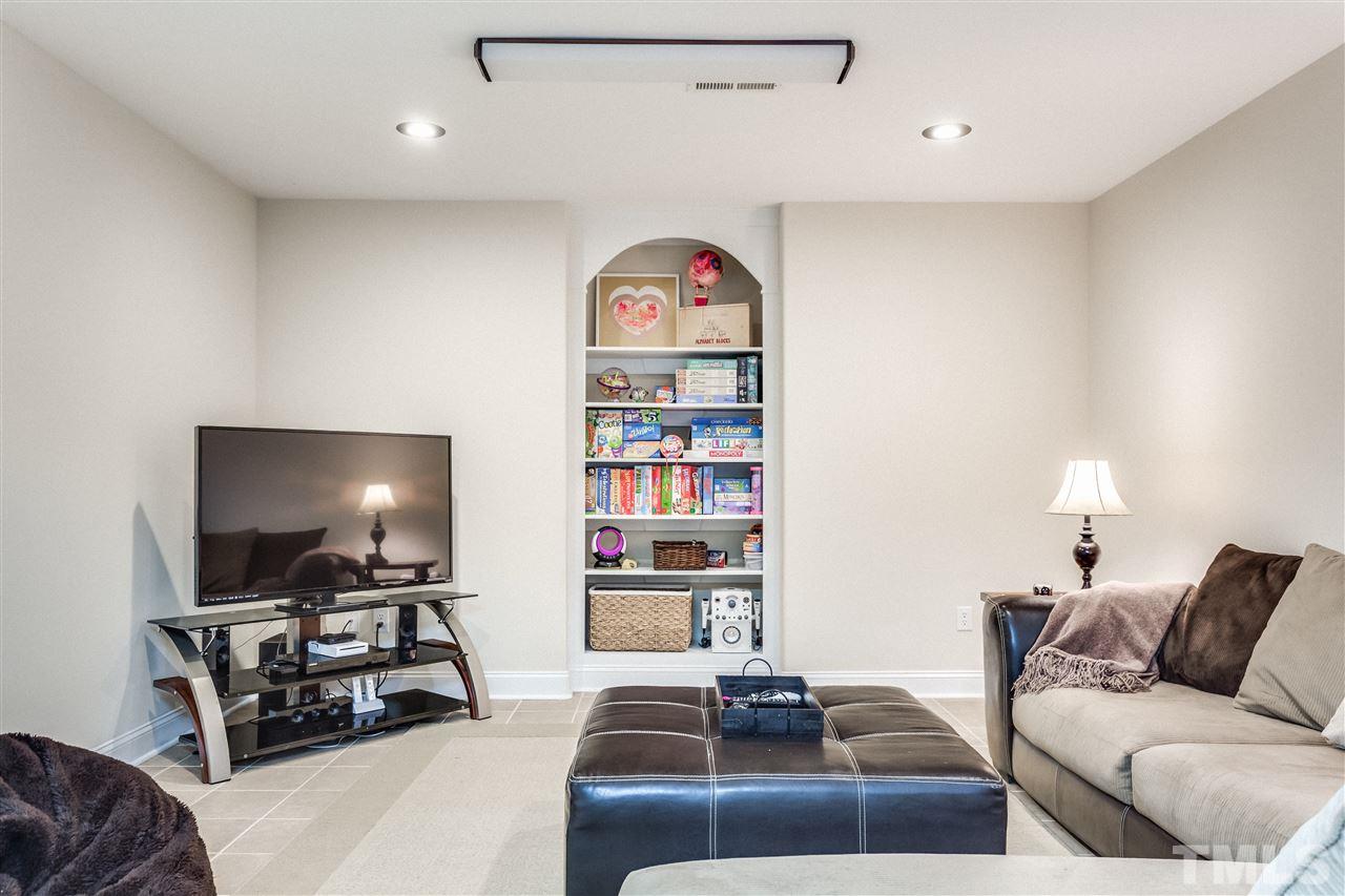 9004 Shellwood Court Raleigh, NC 27617 - Photo 21 of 25 a living room with furniture and a flat screen tv