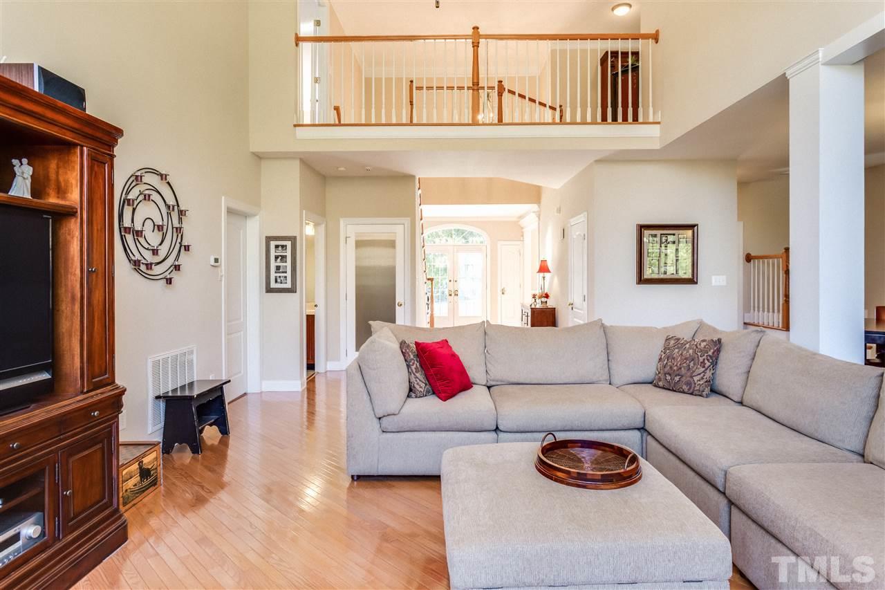 9004 Shellwood Court Raleigh, NC 27617 - Photo 7 of 25 a living room with furniture a flat screen tv and a wall painting