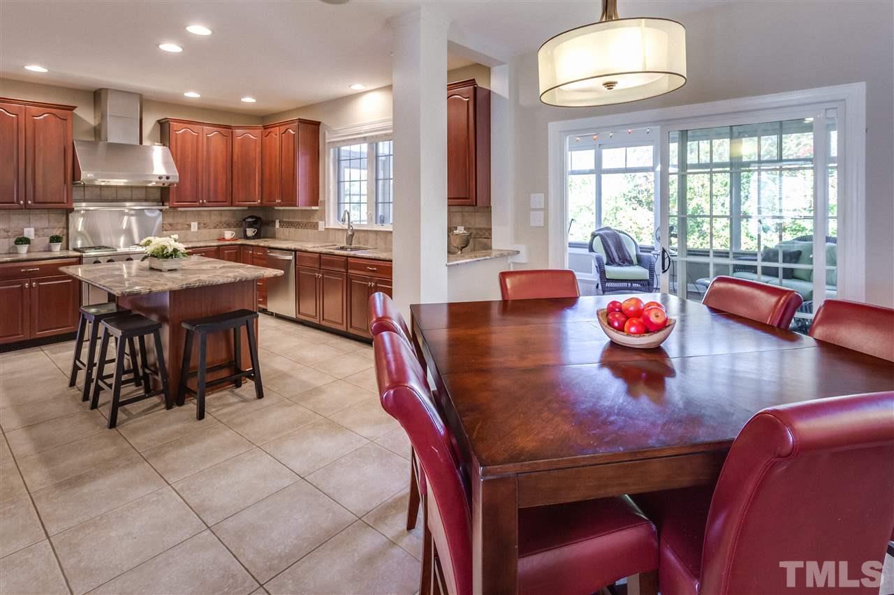 9004 Shellwood Court Raleigh, NC 27617 - Photo 8 of 25 a kitchen with stainless steel appliances granite countertop a stove a sink a dining table and chairs