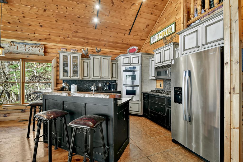 180 Cinnamon Bear Road Mineral Bluff, GA 30559 - Photo 32 of 76 a kitchen with stainless steel appliances granite countertop a refrigerator and a stove top oven