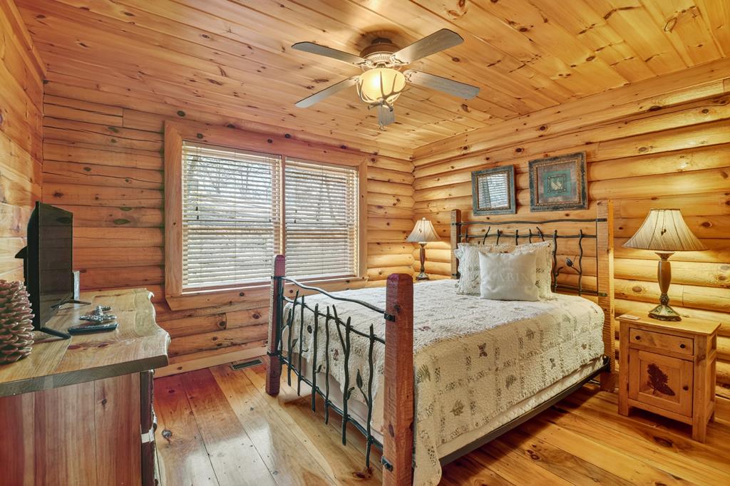 180 Cinnamon Bear Road Mineral Bluff, GA 30559 - Photo 35 of 76 a bedroom with a bed next to a window with the outer view