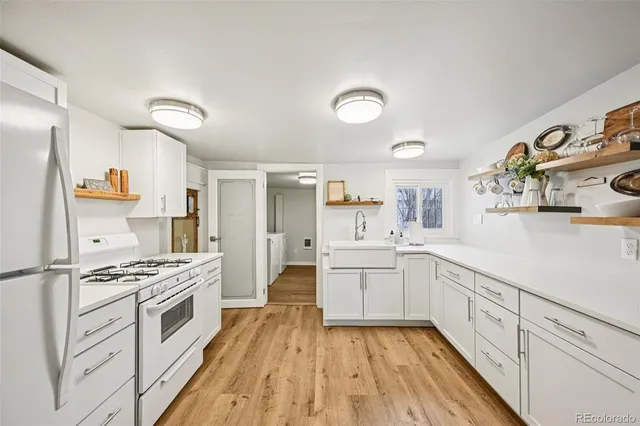 a kitchen with white cabinets and appliances