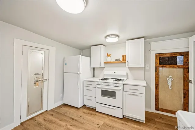 a kitchen with a stove top oven and refrigerator