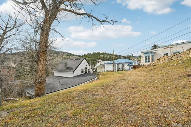 a view of a white house with a yard and sitting area