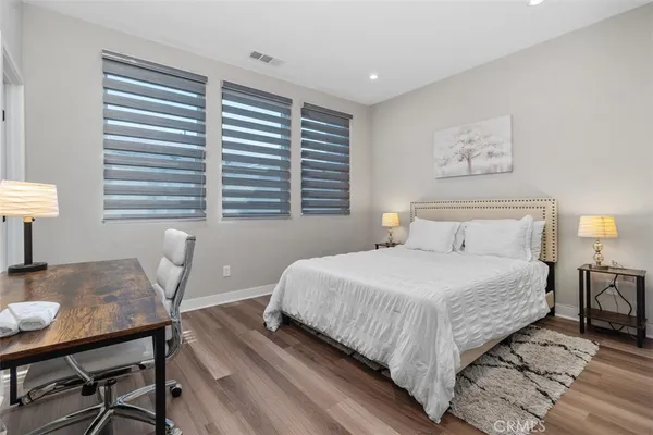 a bedroom with a bed a desk and chair