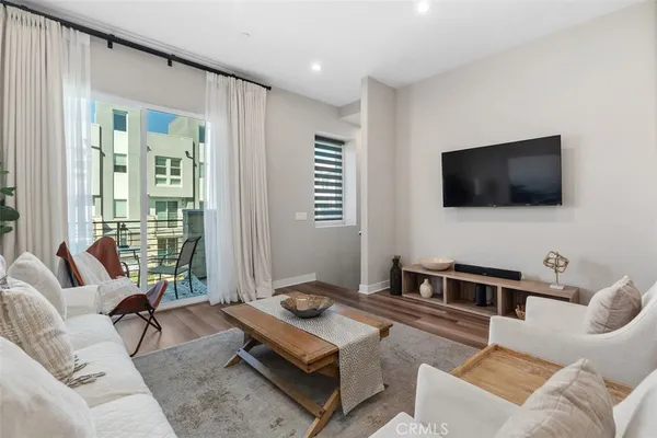 a living room with stainless steel appliances kitchen island granite countertop furniture and wooden floor