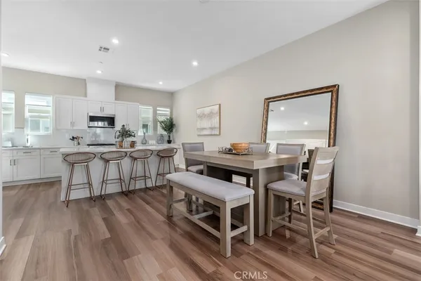 a kitchen with stainless steel appliances granite countertop a white table and chairs