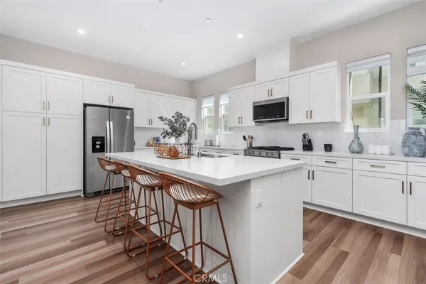 a kitchen with white cabinets sink and stainless steel appliances