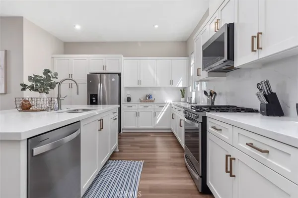 a kitchen with lots of counter top space and painting on the wall
