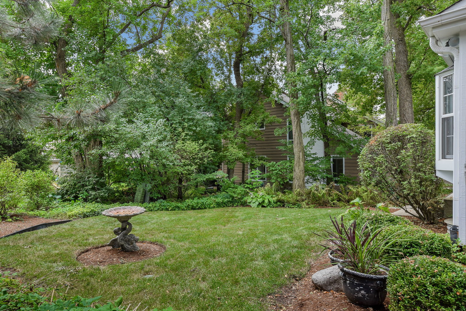 1S771 Carrol Gate Road Wheaton, IL 60189 - Photo 37 of 42 a view of a garden with a bench and trees