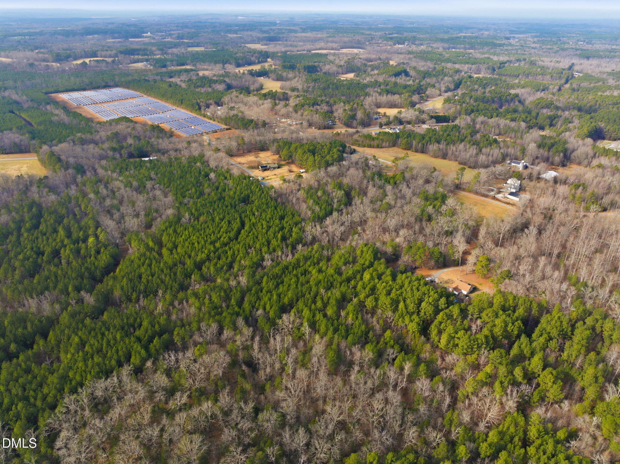 an aerial view of residential houses with outdoor space and trees