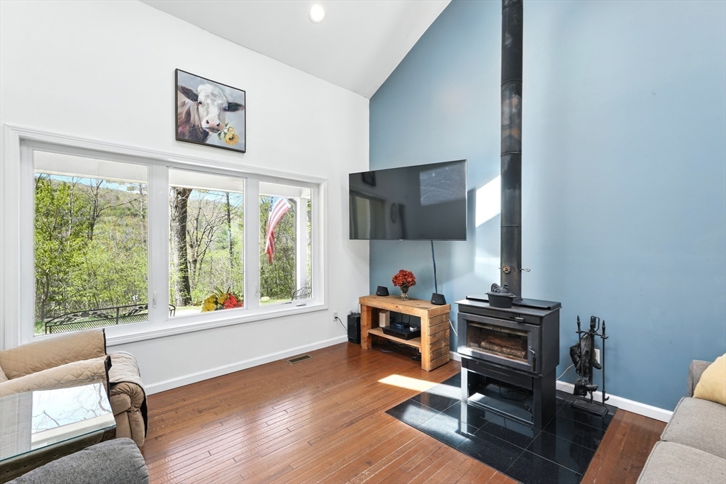 47 Old Chester Road Huntington, MA 01050 - Photo 2 of 36 a living room with furniture a flat screen tv and a floor to ceiling window