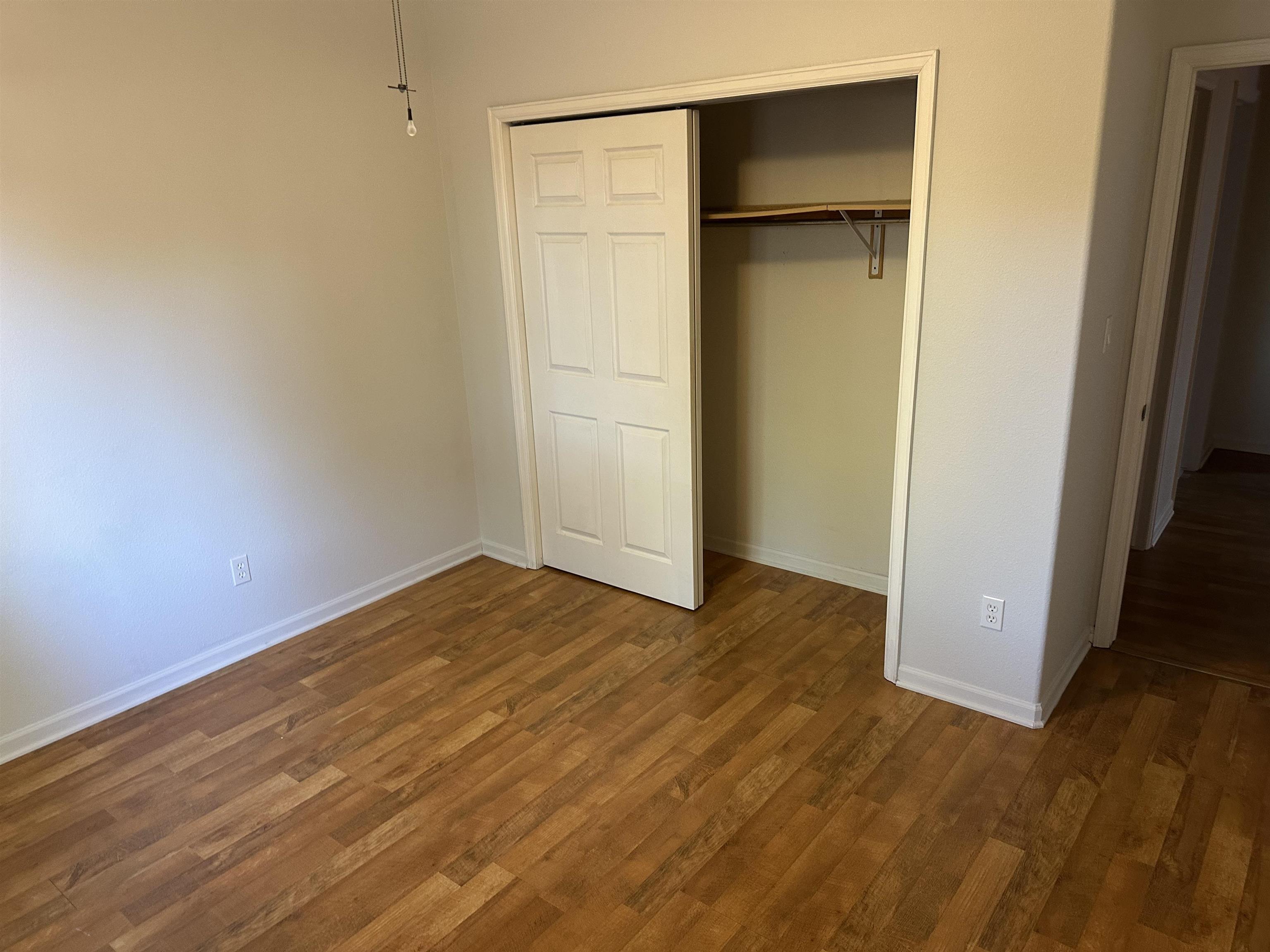 2678 Cambridge Road Grand Junction, CO 81506 - Photo 31 of 32 a view of an empty room with wooden floor and a door