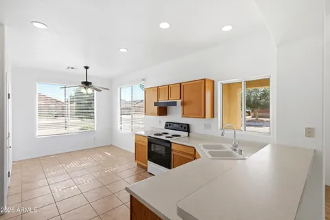 a view of a kitchen with a sink and a chandelier fan