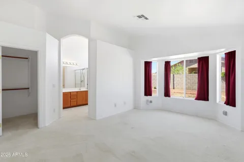 a view of an empty room with window and front door