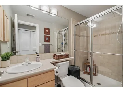 a bathroom with a sink toilet double vanity and shower