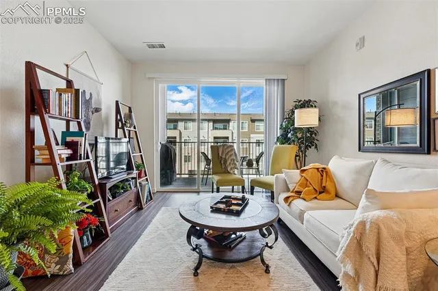 a living room with furniture a bookshelf and a large window