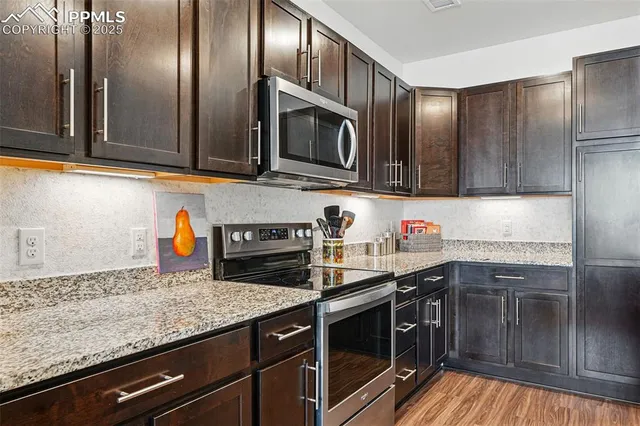 a kitchen with granite countertop stainless steel appliances and wooden cabinets