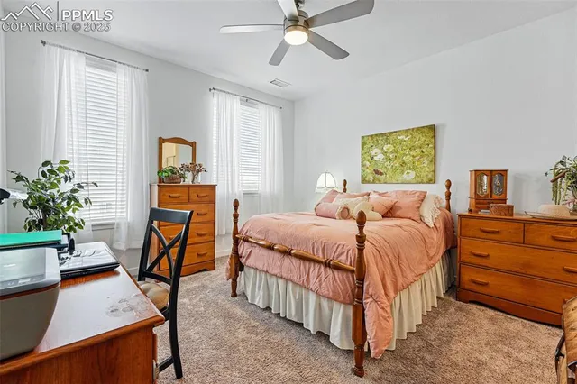 a bedroom with a bed a couch and potted plant