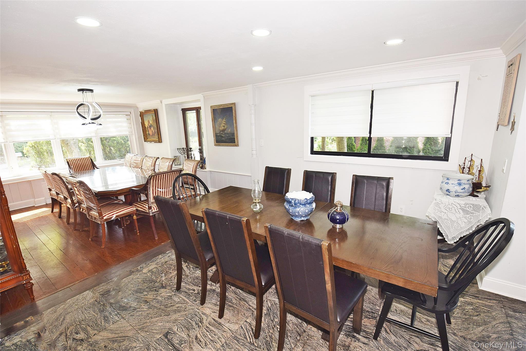 Recessed lighting throughout, crown molding, large window with ample natural light, marble-finish flooring, and wood flooring