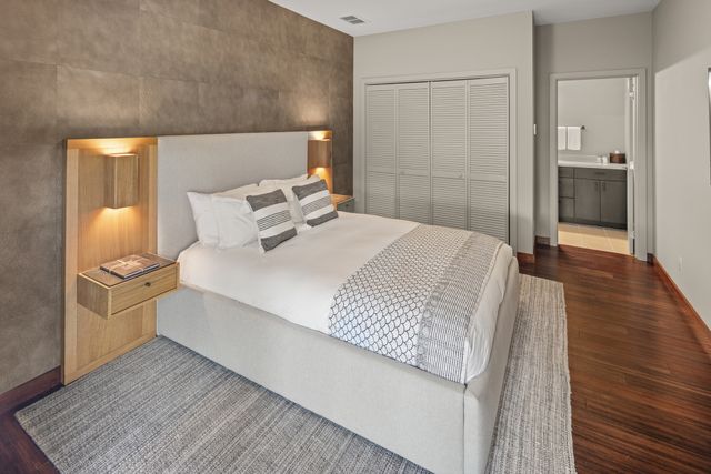 a bedroom with a bed and wooden floor