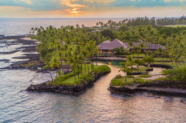 an aerial view of a house with a garden and lake view