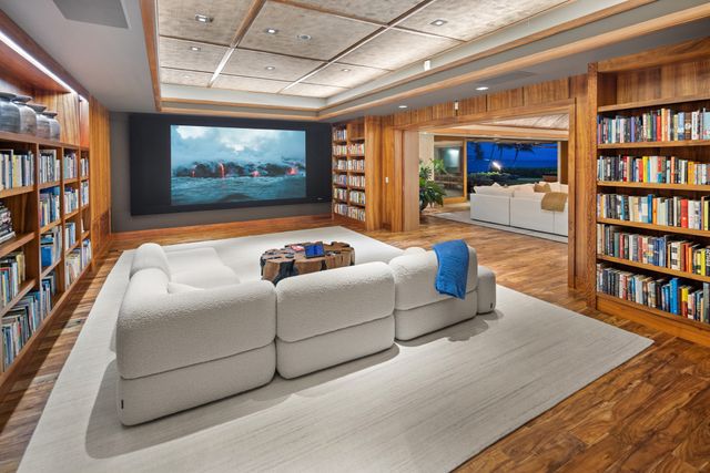a living room with hard wood floors and a book shelf