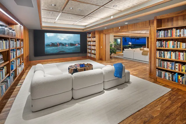 a living room with hard wood floors and a book shelf