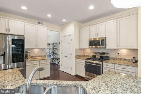 a kitchen with kitchen island granite countertop a sink a counter top space and cabinets