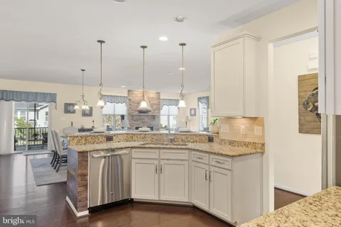 a kitchen with kitchen island a dining table chairs a sink and a stove