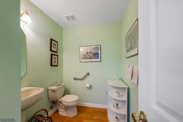 a white toilet sitting next to a bathroom sink and a mirror