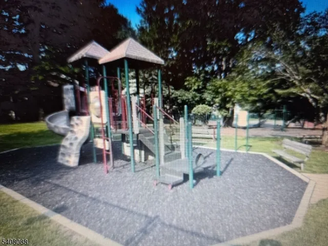 a view of a park with plants and a slide