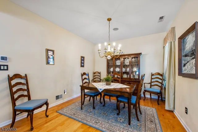 a view of a dining room with furniture a chandelier and wooden floor