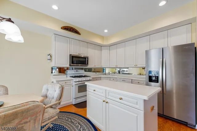 a kitchen with a sink a stove a refrigerator and white cabinets