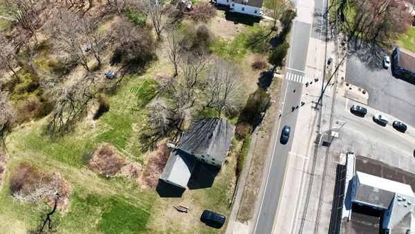 an aerial view of a house with a yard and green space