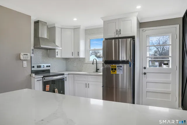 a kitchen with granite countertop stainless steel appliances and refrigerator