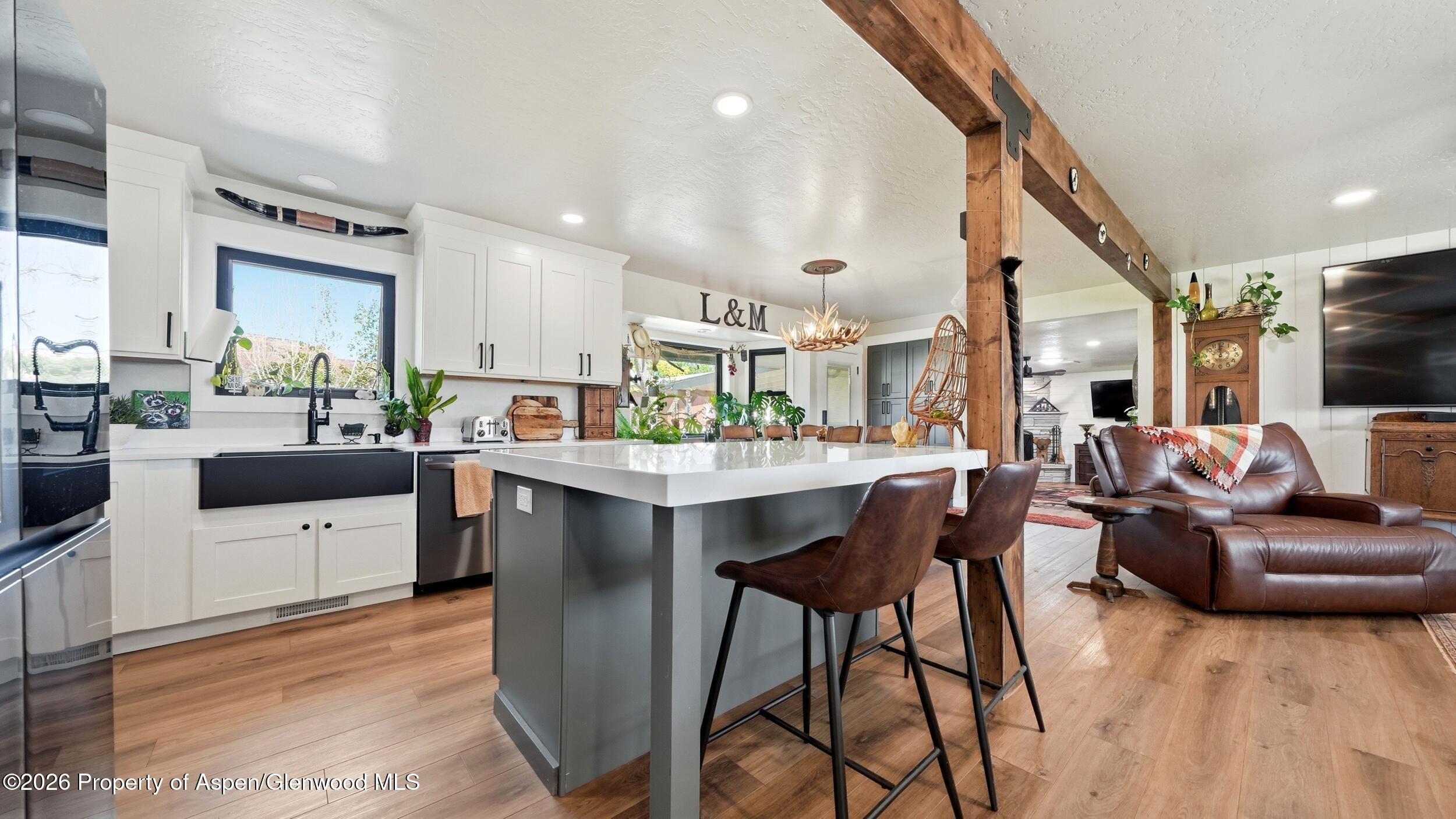 445 South Camp Road Grand Junction, CO 81507 - Photo 11 of 37 a kitchen with stainless steel appliances kitchen island granite countertop a table chairs sink and wooden cabinets