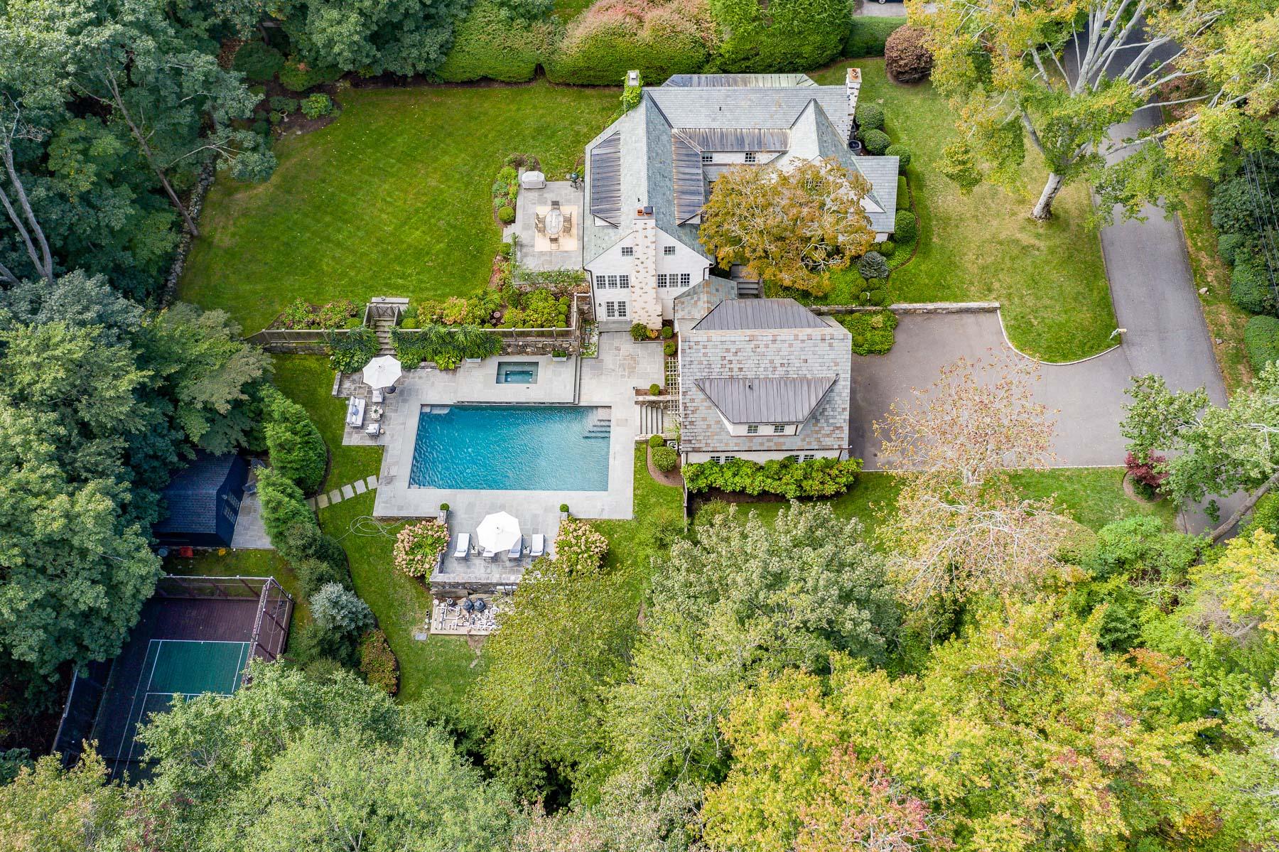 an aerial view of a house with a garden and lake view
